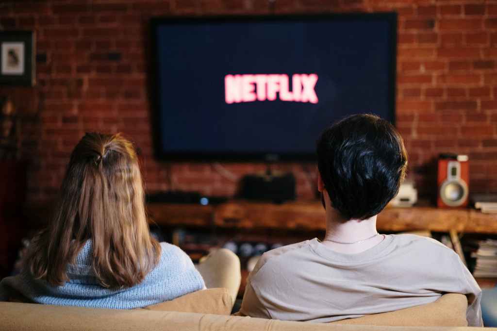 Para siedzi na kanapie oglądając Netflixa