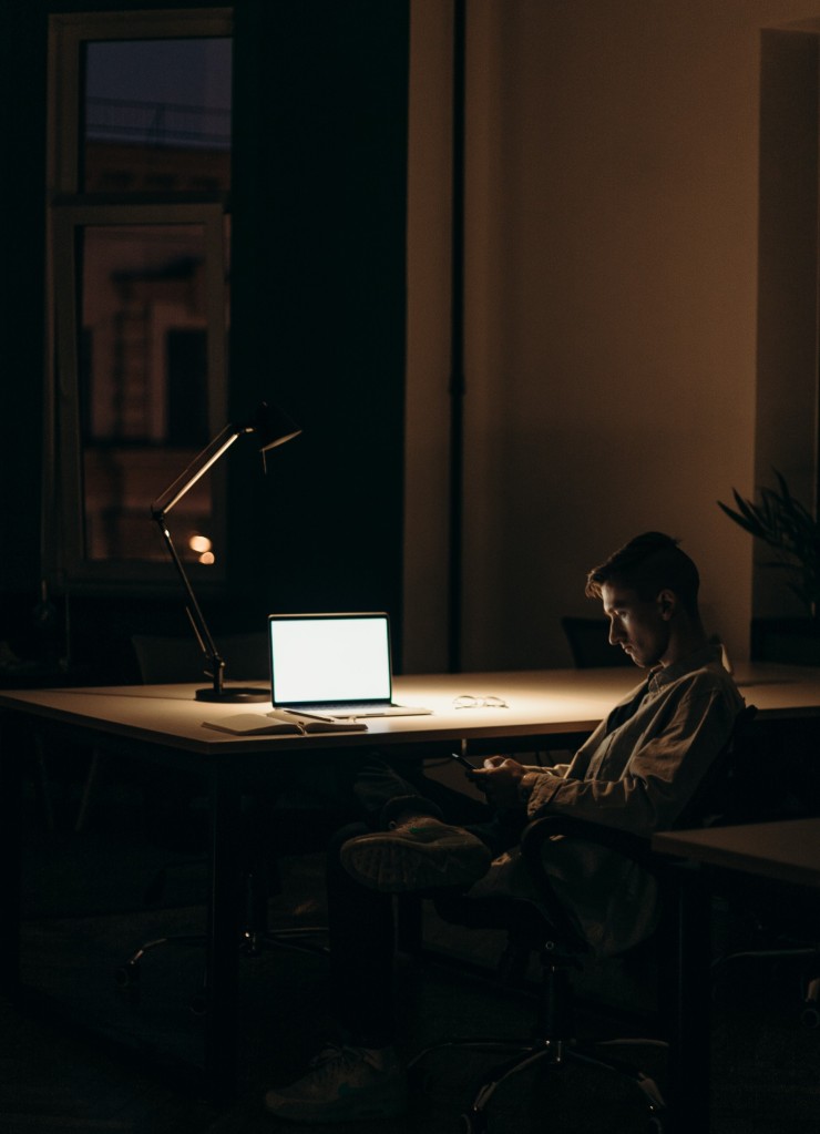 Mężczyzna siedzący przy komputerze w nocy